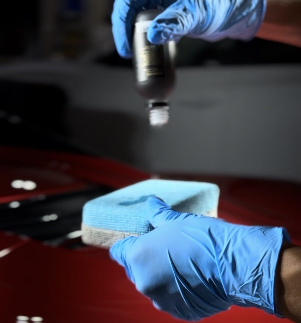 Ceramic coating being poured onto an applicator pad — 1-cut sealant application on red paint