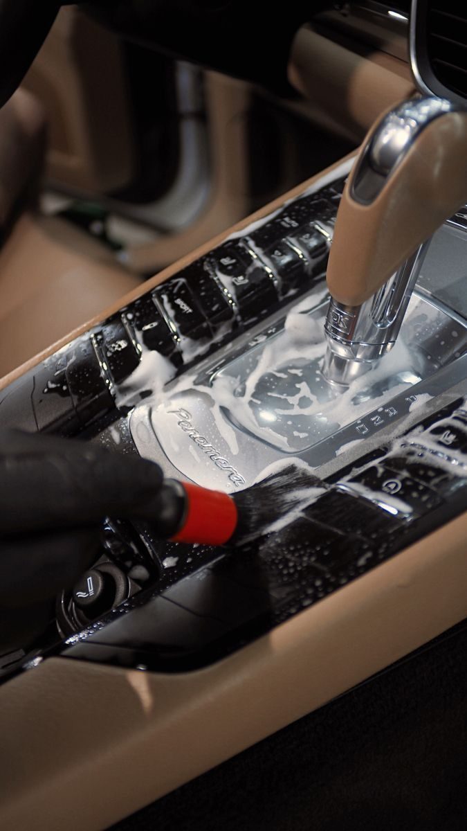 Interior detailing — center console deep clean on a luxury sedan